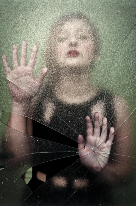 Ragazza vista attraverso specchio rotto