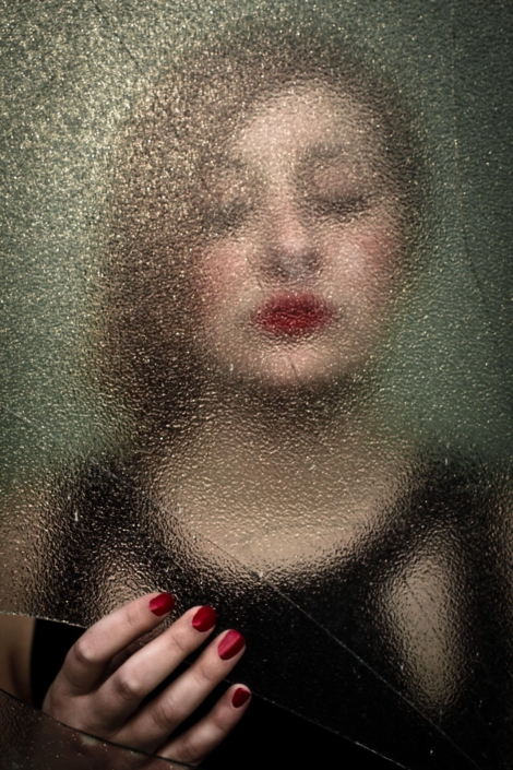 Ritratto un viso di una ragazza vistro attraverso uno specchio